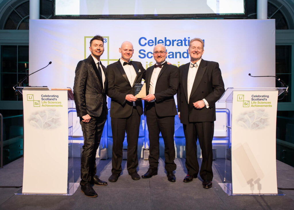 Image of Antibody Analytics accepting the Scotland's Life Sciences Innovation - Pharma Services and Drug Discovery Award 2023 from host Sean Batty and Mark Cook.