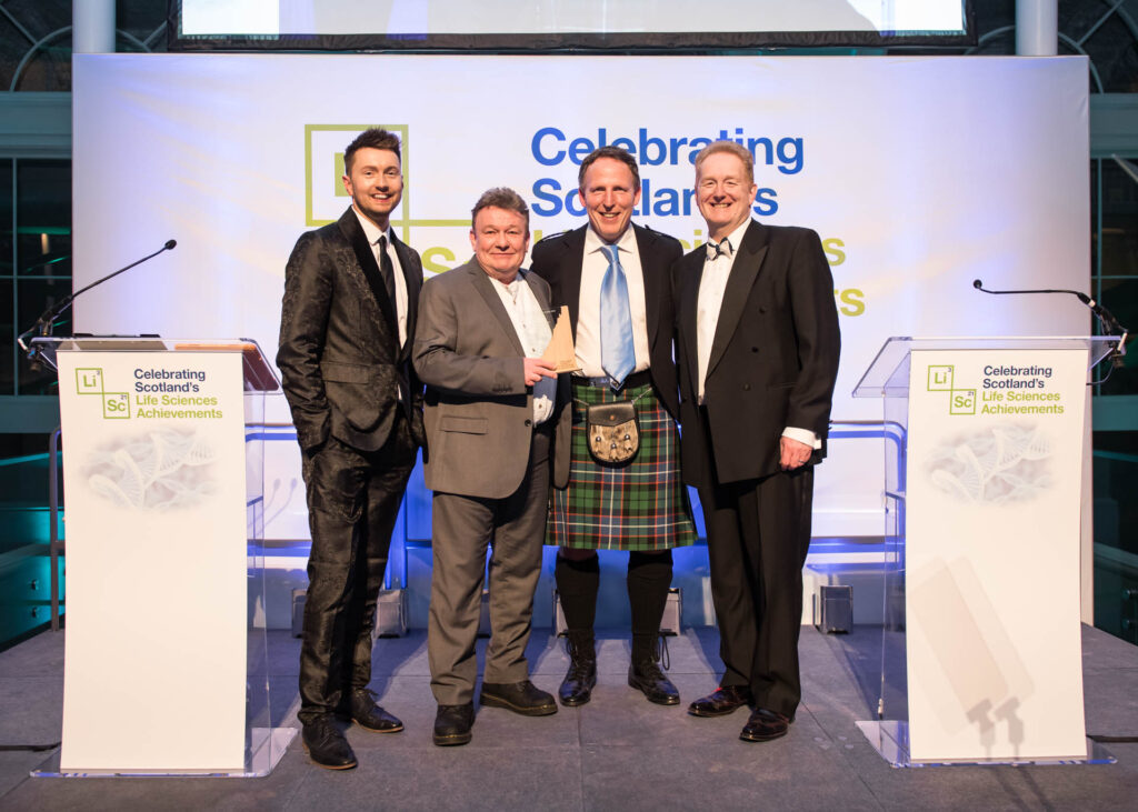 Image Roslin Technologies COO John Clinkenbeard and Roslin Technologies VP of Cell Innovation Joe Lee accepting the Scotland's Life Sciences Innovation - Animal Health, Agritech and Aquaculture Award 2023 from Mark Cook and host Sean Batty.