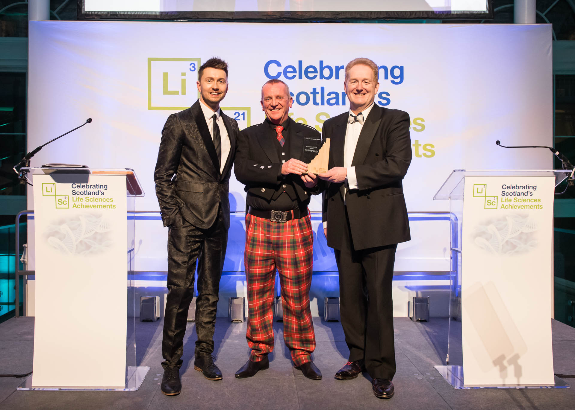 Image Dr Archie Lovatt accepting the Scotland's Life Sciences Business Leadership Award 2023 from host Sean Batty and Mark Cook.